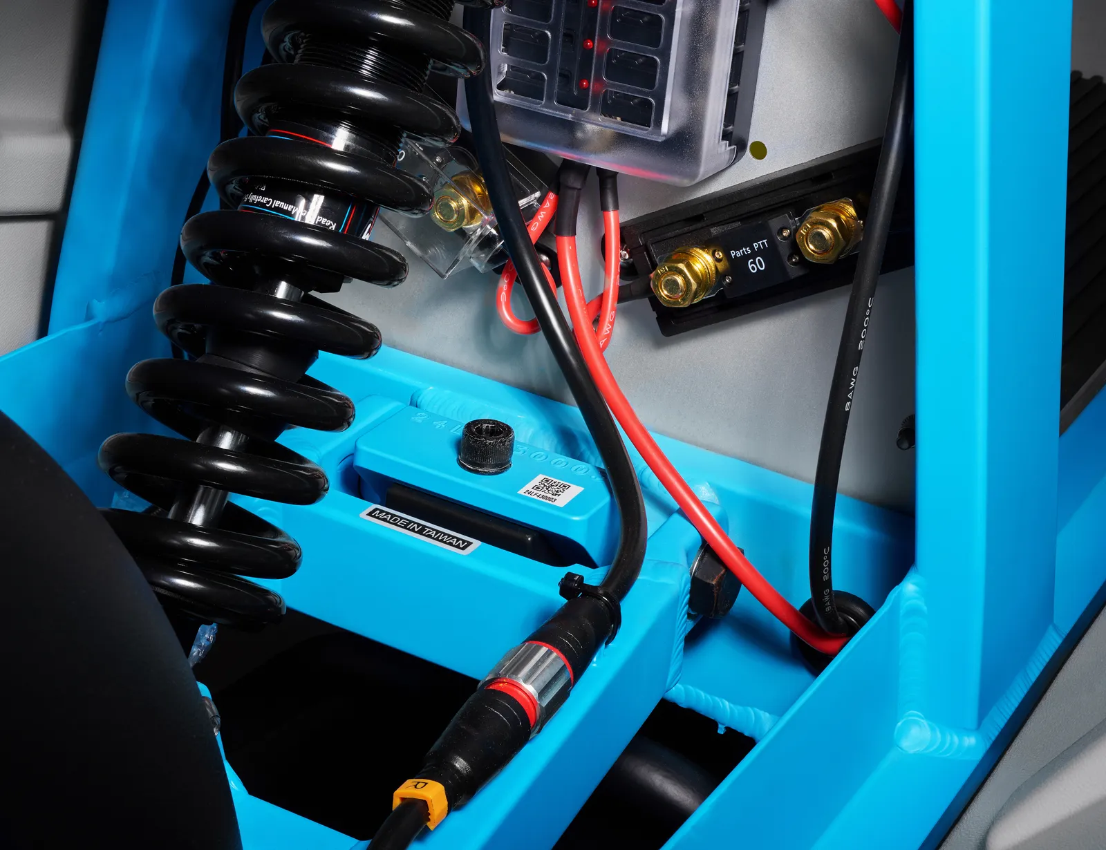 Close-up of the coil-over-oil rear damper mounted to the blue frame