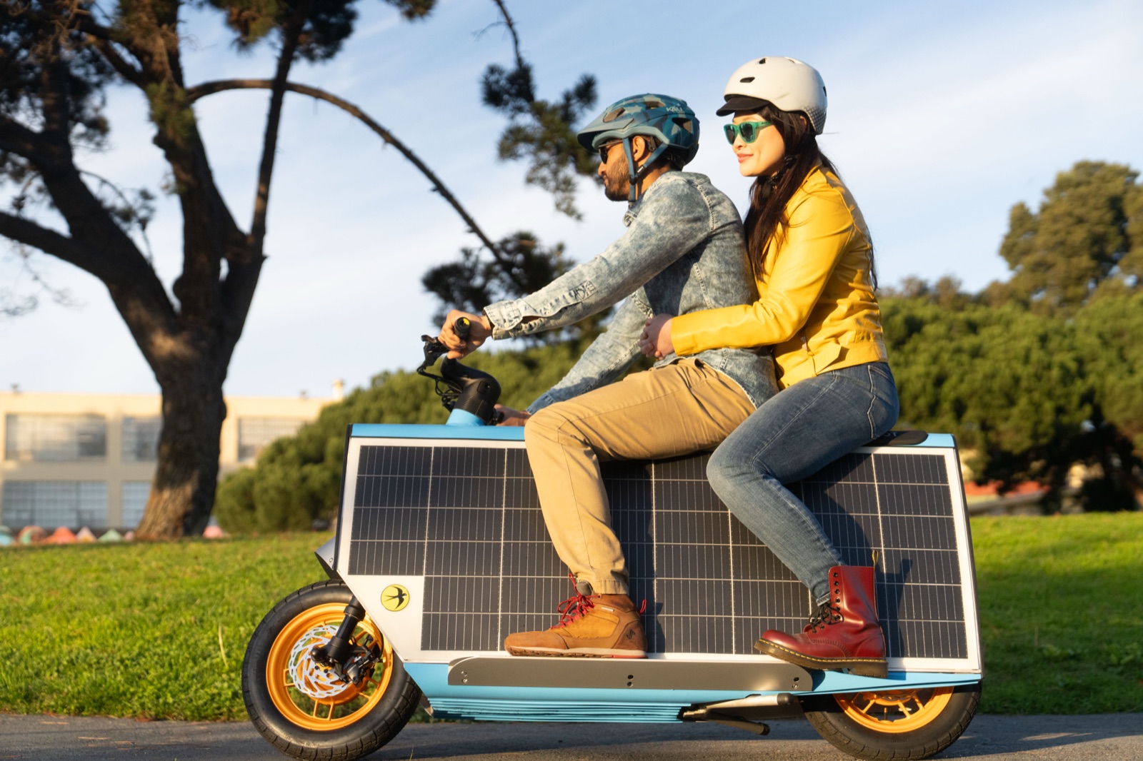 Two riders sharing the bench seat on a park path